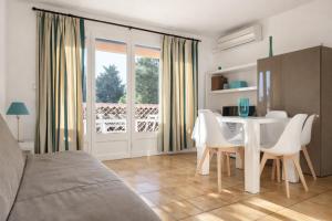 a living room with a white table and chairs at Studio cabine climatise Malibu Village in Canet-en-Roussillon +9 photos