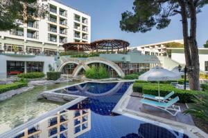 an image of a hotel swimming pool with a building at Limak Atlantis Deluxe Hotel Belek in Belek