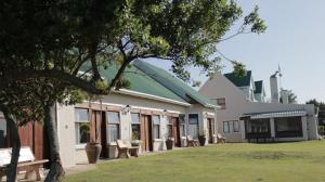 a building with a group of benches in front of it at TNiqua Stable Inn in Plettenberg Bay