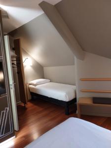 a small room with two beds in a attic at ibis Besançon Centre Ville in Besançon +88 photos