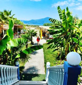 a woman walking down a path in a garden at Apartments Vista Mar in Orikum