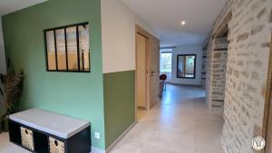 a hallway with green and white walls and a bench at Chez le Paul Jacques in Seigny