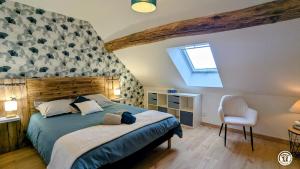 a bedroom with a bed and a chair at Chez le Paul Jacques in Seigny