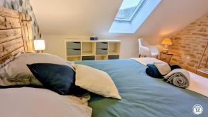 a bedroom with a large bed with pillows on it at Chez le Paul Jacques in Seigny