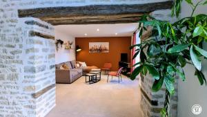 a living room with a brick wall at Chez le Paul Jacques in Seigny +28 photos