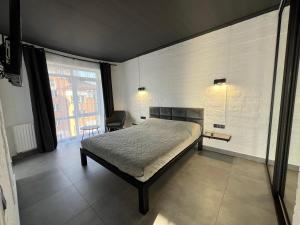 a bedroom with a bed and a desk and a window at Kalinova Sloboda Apart РЕЗЕРВНЕ ЖИВЛЕННЯ in Krykhivtsi