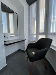 a living room with a chair and a mirror at Kalinova Sloboda Apart РЕЗЕРВНЕ ЖИВЛЕННЯ in Krykhivtsi +18 photos