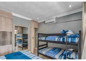 a room with three bunk beds in a room at Mtunzi Park 18, Scottburgh in Vosburg +11 photos