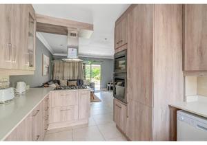a kitchen with wooden cabinets and a stove top oven at Mtunzi Park 18, Scottburgh in Vosburg