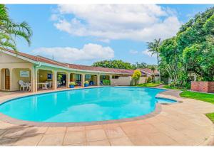 a swimming pool in front of a house at Mtunzi Park 18, Scottburgh in Vosburg