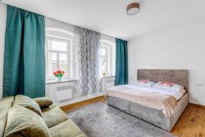 a bedroom with a bed and a couch at Bob Apartmá - Resort Abertham in Abertamy