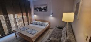 a small bedroom with a bed and a lamp at Mimoza Apartments in Đenovići