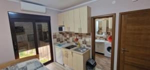 a small kitchen with a sink and a washing machine at Mimoza Apartments in Đenovići