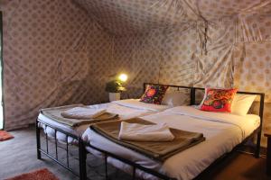 two twin beds in a room with wallpaper at Zero Degree Camps in Joshīmath