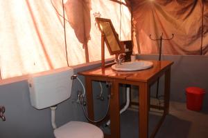 a bathroom with a toilet and a sink and a mirror at Zero Degree Camps in Joshīmath +14 photos