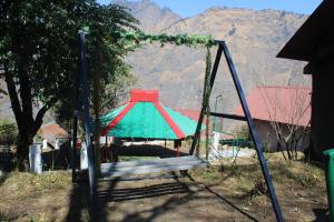 a swing set in a yard with a mountain in the background at Zero Degree Camps in Joshīmath