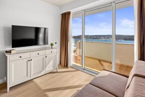 a living room with a tv and a large window at Family Resort del Mar in Pula