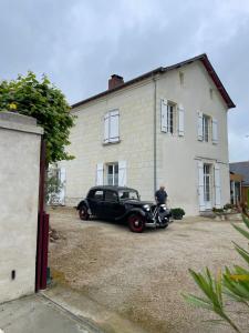 a black car parked in front of a house at Les tilleuls de Mary in Rillé