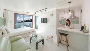 a woman standing at a counter in a living room at Namhae Briant Oceanview Spa Pension in Namhae