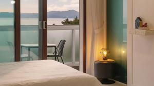 a bedroom with a bed and a table and a window at Namhae Briant Oceanview Spa Pension in Namhae