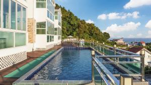 a swimming pool on the balcony of a building at Namhae Briant Oceanview Spa Pension in Namhae