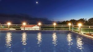 a large swimming pool at night with lights at Namhae Briant Oceanview Spa Pension in Namhae +3 photos