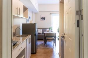 a kitchen with a black refrigerator and a table at Priscilla Suites Mactan by Amani Grand Resort in Mactan Cebu International