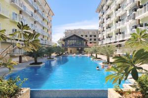 a swimming pool in the middle of two apartment buildings at Priscilla Suites Mactan by Amani Grand Resort in Mactan Cebu International