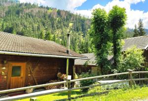 a wooden house with a fence in front of it at Almliesl THUR-746 in Lovara +9 photos