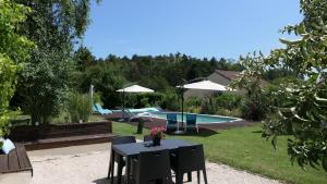 a table with flowers on it next to a pool at Le Moulin du Clapier- Gîte La Banette in Sorges