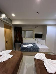 a hotel room with two beds and a television at Bostan Hotel in Cairo