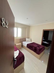 a hotel room with two beds and a television at Bostan Hotel in Cairo