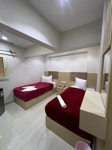two beds in a room with red sheets at Bostan Hotel in Cairo +3 photos