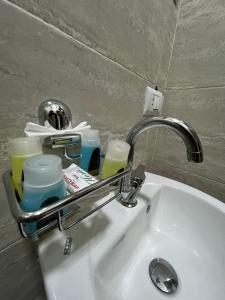 a bathroom sink with a faucet and cups on it at Bostan Hotel in Cairo
