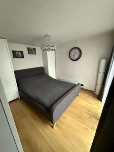 a bedroom with a bed and a clock on the wall at Tęczowy Domek - Balia z hydromasażem in Darłowo