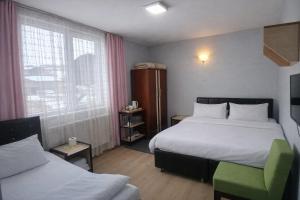 a hotel room with two beds and a window at Arı Otel in Erzurum