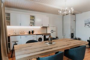 a kitchen and dining room with a wooden table and chairs at STRIĶU15 - Plašs studio dzīvoklis in Saldus +9 photos