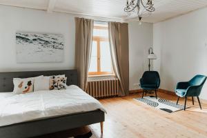 a bedroom with a bed and a chair and a window at STRIĶU15 - Plašs studio dzīvoklis in Saldus