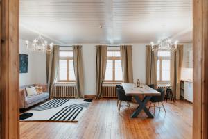 a living room with a table and a couch at STRIĶU15 - Plašs studio dzīvoklis in Saldus