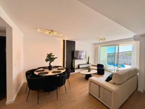 a living room with a table and chairs and a couch at Star Light Apartment in Câmara de Lobos