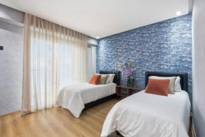 two beds in a room with a blue wall at OXANA By Atlasia in Agadir +41 photos