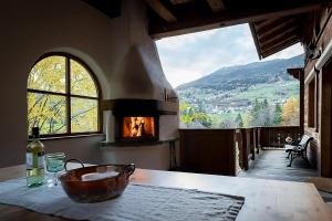 a room with a fireplace and a table with a bottle of wine at Ferienhaus-Pitztal in Wenns