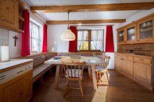 a kitchen with a table and chairs and red curtains at Ferienhaus-Pitztal in Wenns
