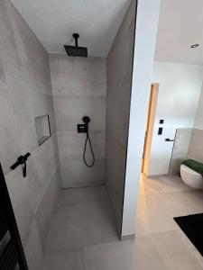 a bathroom with a shower with a toilet in it at Alpinelodge8 in Innsbruck +17 photos
