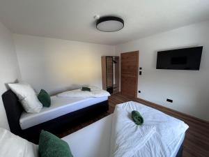 a small room with two beds and a tv at Alpinelodge8 in Innsbruck