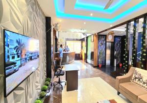 a living room with a large flat screen tv on a wall at Hotel Heritage Inn in Balasore