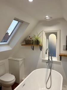 a bathroom with a tub and a toilet and a window at FRESH Flat in Leek, Staffordshire in Leek +27 photos