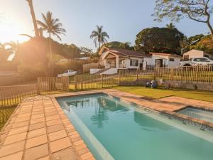 a swimming pool in a yard with a fence at Picasso - Zur See in Ballito