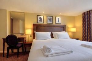 a hotel room with a bed with towels on it at Manchester Airport Stanley Hotel by Belvilla in Handforth