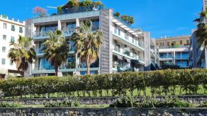 an apartment building with palm trees in front of it at Il Rifugio di Boccadasse in Genoa